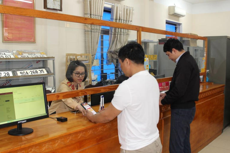 Cán bộ hướng dẫn người dân tại Hà Nam khai báo thông tin mua bán xe trực tuyến. Ảnh: Công an tỉnh Hà Nam